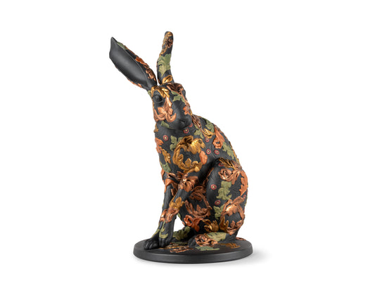 A black porcelain hare with intricate autumnal leaves in green, red and copper across its body