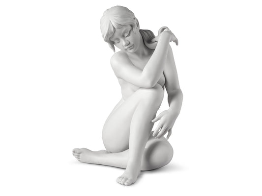 a matte white porcelain sculpture of a young woman with her hair tied back, shown in nude
