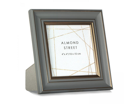 A dark grey moulded photo frame with copper details around the edges