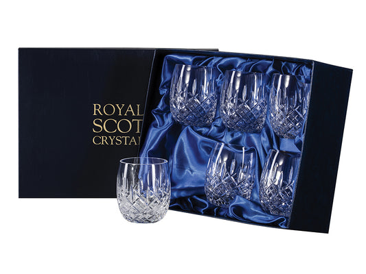 A set of six matching barrel shaped glasses with a cut pattern on the outside that consists of a bed of diamonds around the base, topped with single flicks going towards the smooth rim. They come in a navy-blue silk-lined presentation box with gold branding on the lid.