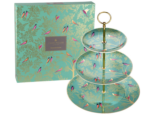 This three-tier cake stand is decorated with a green transfer featuring gold foliage and brightly coloured birds. the connecting rods are gold, with a loop at the top for ease of carrying.