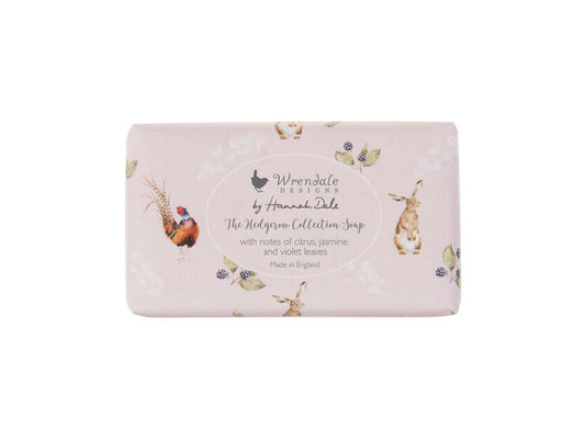 A bar of soap wrapped in light pink paper with animals and branding on it
