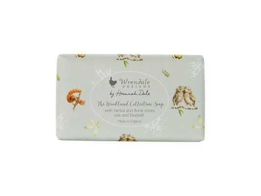 A bar of soap wrapped in light green paper that has woodland animal illustrations on it