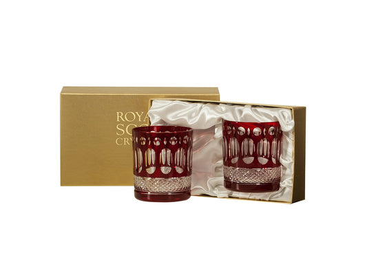 A pair of large crystal tumblers with red exteriors cut to reveal clear panels. They come in a gold presentation box that is lined with white silk.
