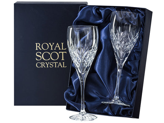 A pair of large wine glasses with a bed of diamonds cut above the stem with a five-pointed fan above them, reaching up towards the smooth rim. They come in a navy-blue silk-lined presentation box with gold branding on the lid.