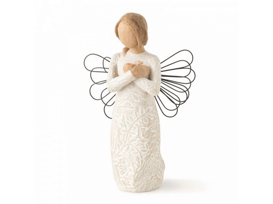 A Willow Tree cast stone figurine of a feminine angel with overlapped hands resting on her chest, wearing a dress embossed with flowers, leaves, and a small 3D heart. Adorned with wire wings resembling sparkler art and painted in soft, earthy tones of cream, beige, and brown.