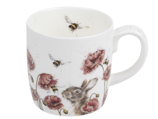 A fine bone china mug, with a watercolour illustration of bees floating above poppies and a hare at the bottom corner, peeking through the flowers.