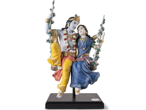 The love of Radha and Krishna inspires Hindu celebrations like Jhulan Yatra, the swing festival, during the monsoon season. Their story is intertwined with the arrival of rains, blossoming lotus flowers, and fragrant air in Vrindavan. The High Porcelain creation depicts Radha and Krishna on a swing adorned with handmade flowers and meticulously detailed costumes, symbolizing their spiritual significance. Suspended over a wooden base, this divine couple perpetually swings, expressing their eternal love.