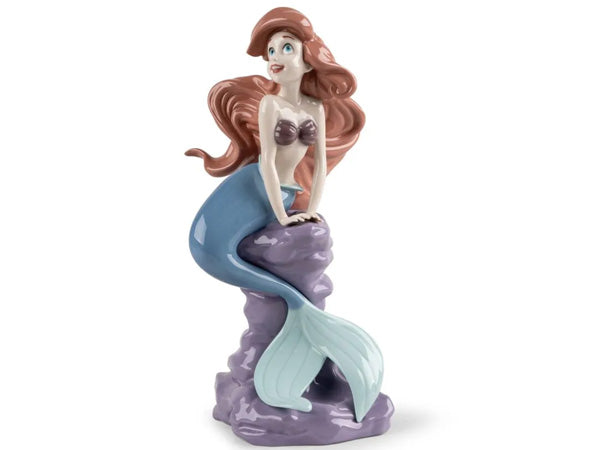 Ariel, the iconic main character from Disney's timeless classic, "The Little Mermaid," is artfully brought to life through the masterful hands of Lladró's gifted artisans. This exquisite creation is meticulously handcrafted from glazed porcelain, meticulously capturing every delicate detail of the beloved mermaid princess.