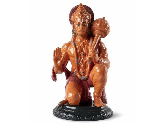 An orange figure of Lord Hanuman, the Hindu deity. He wears richly ornate dress and is kneeling with something over his shoulder. His headdress is also detailed.