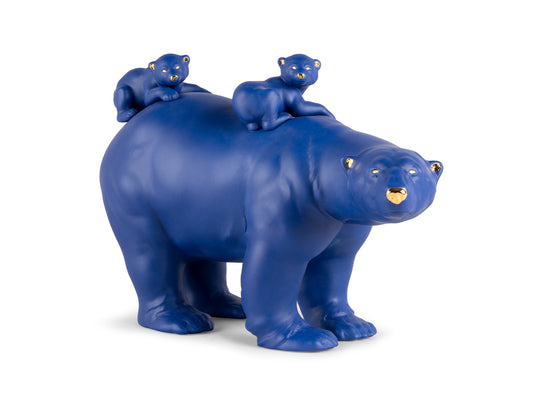 a matte blue figure of a mother polar bear and two babies on her back with gold details