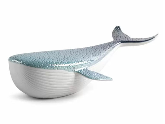 A stylised sculpture of a whale in blue and white porcelain, with a dotted blue pearlised top and a ribbed matte white belly