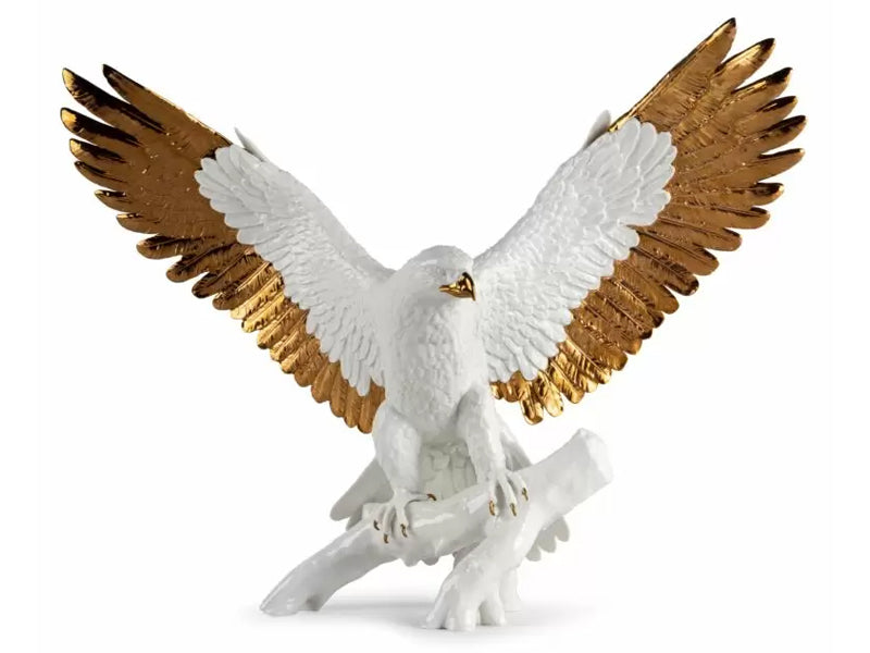 A white glazed porcelain figure of an eagle landing on a branch with a gold beak, talons and outer wing feathers. The bird's wings are stretched out as if ready to take flight