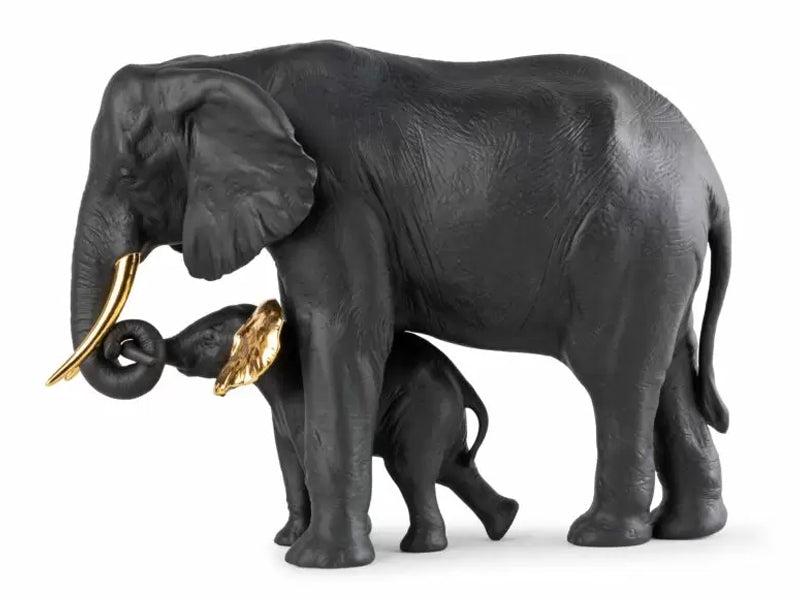 A mother and baby elephant with trunks entwined, made of matte black porcelain with gold detailing