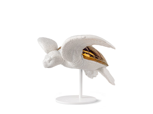A white glazed porcelain turtle with a copper shell, mid swim