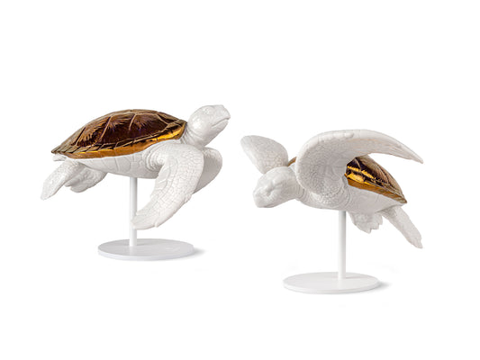 A pair of turtles made of glazed white porcelain with copper shells