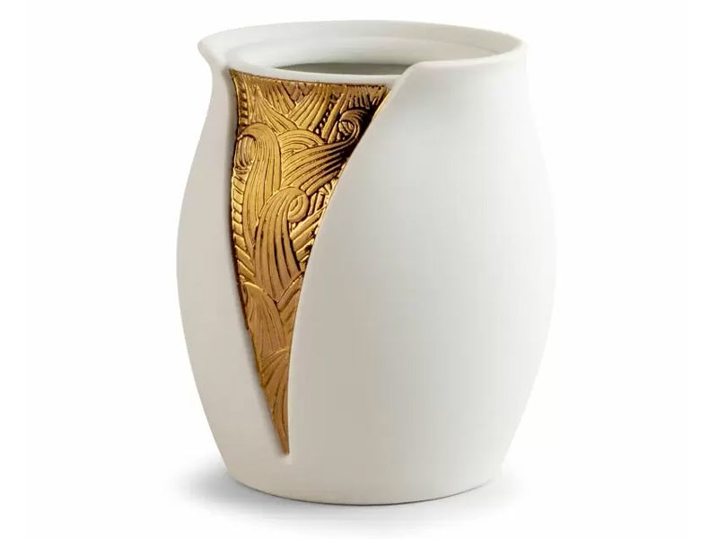 A white porcelain pencil pot with a slit in one side, revealing a patterned gold panel in the pot.