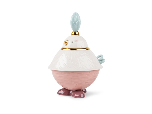 A covered sugar bowl in the shape of a stylised bird, complete with feet, a blue tail that is a spoon inside the dish and a white lid with a blue plume at the top of its head that acts as a handle