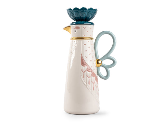 A cream coffee pot that is decorated and embellished to look like a bird with dramatic plumage on its head