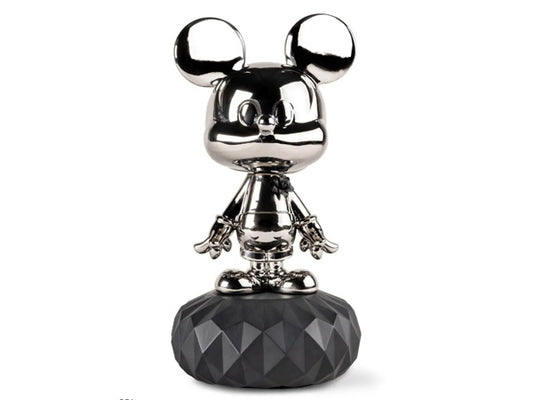 Mickey's body boasts a gleaming platinum luster, adorned with a meticulously handcrafted black porcelain flower, petal by petal. The sculpture is elegantly positioned on a black porcelain base featuring a geometric facet design. There is also a metallic finish and matte black porcelain 