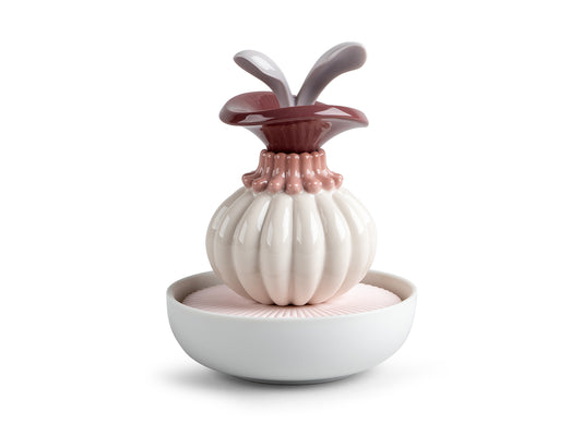 A porcelain sculpture with a white bowl full of matte pink porcelain, topped with an abstract flower head in cream, pink and mauve