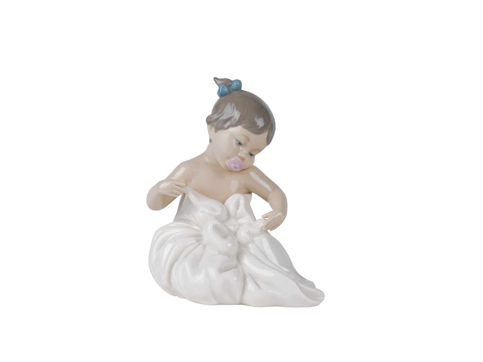An adorable glazed porcelain figurine of a young girl with her lovely dark hair tied up into two buns, holding and looking at her favourite blanky. A memory I am sure a few of us can share. Size: 16 x 13 cm By Nao Product Code: 02001337