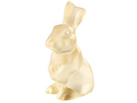 A golden lustre crystal figurine of a rabbit sat on its back legs, with its front paws resting in front of it.