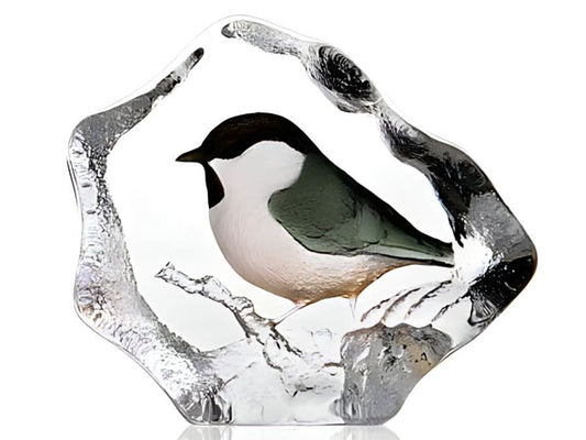 A painted crystal sculpture depicting a common marsh tit with a black cap and bib, contrasting with white cheeks and a white belly.