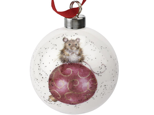 A white china bauble with a mouse sitting on top of a red bauble painted on one side, hanging from a red ribbon