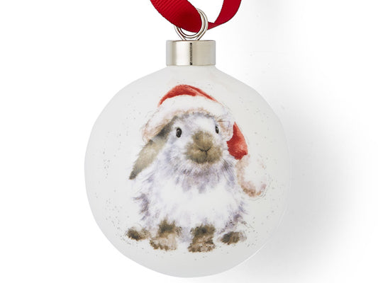A white bauble with a grey rabbit wearing a santa hat on it, hung from a red ribbon