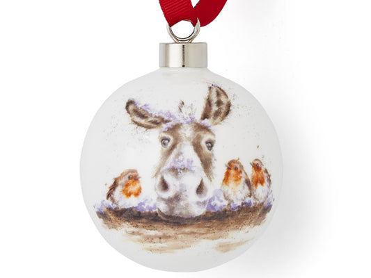 A white porcelain bauble with a watercolour image of a donkey leaning on a fence with three robins around him, hung off a red ribbon