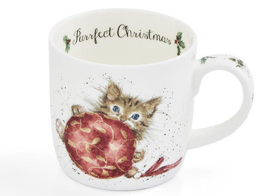 On the front of this white china mug is a charming depiction of a playful cat with a red bauble.