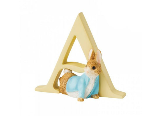 A yellow letter a figure with a small statue of a rabbit in a blue jacket and white shirt crawling under it