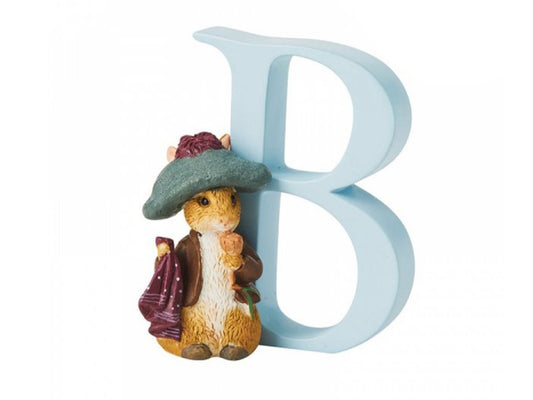 A pastel blue letter B with a statue of Benjamin Bunny, a brown rabbit who wears a darker blue jacket and a floppy teal hat and carries a red handkerchief