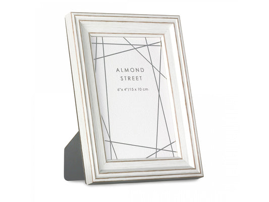 A white photo frame with a moulded surround and gold detailing