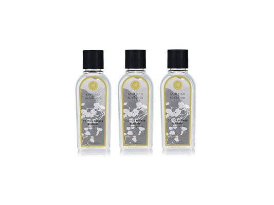 Three bottles of fragrance lamp liquid with a floral motif on the grey label, with clear bottles and black lids.