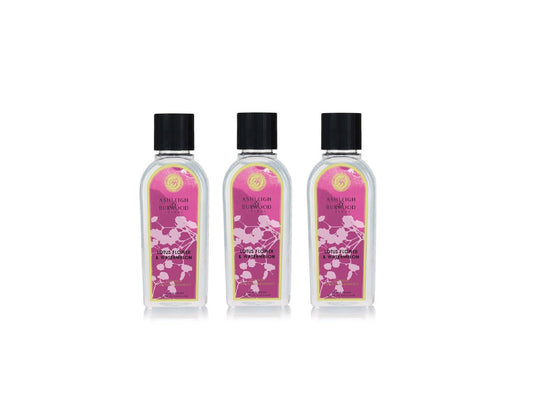 Three bottles of lamp liquid with pink floral labels and black caps