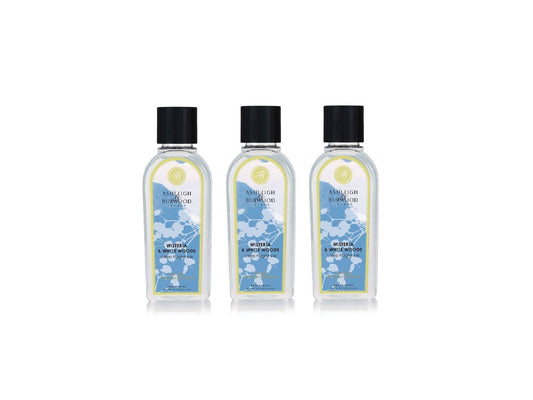 Three clear bottles of lamp liquid with floral blue labels and black lids