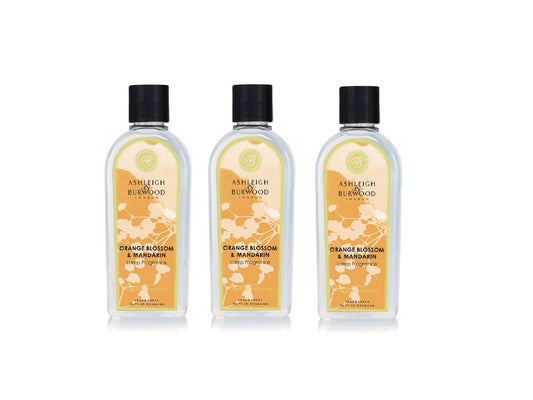 Three bottles of orange blossom and mandarin lamp fragrance in clear bottles with floral orange labels and black caps