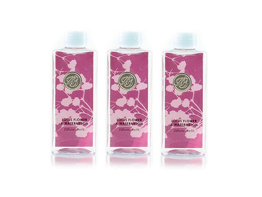 Three bottles of reed diffuser liquid with a pink and white floral pattern and white lids
