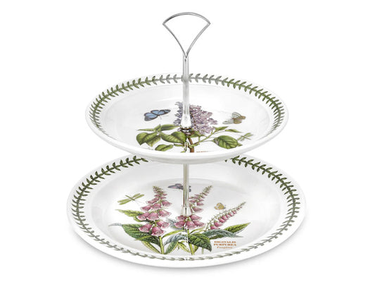 A two tier china cake stand featuring one larger plate adorned with an illustration of Foxgloves and the top smaller plate featuring Garden Lilac motifs. The edges of the plates are lined with Botanic Gardens iconic laurel leaf design.