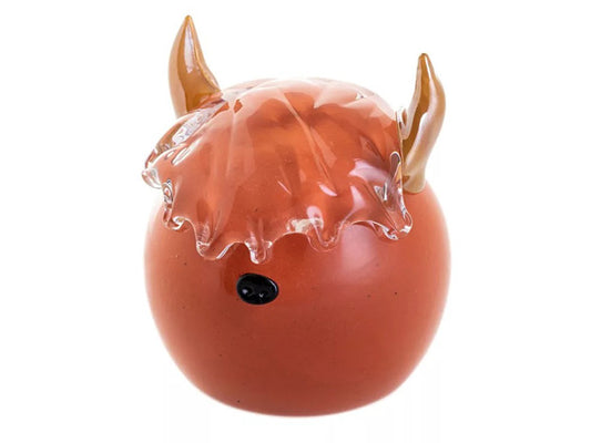 A Caithness Highland Cow Paperweight, featuring a russet-coloured glass body in a classic round shape. Details include a 3D black nose, eyeless face, and clear glass fringe mimicking the iconic features of a Highland Cow, complete with brown glass horns.