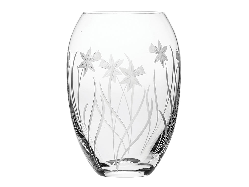 A crystal barrel vase with delicate daffodils engraved on the outside