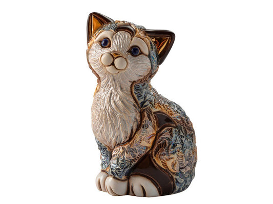 A porcelain kitten figurine sat upright, its fur its coloured in the distinct calico cat features, with grey swirls blending into orange, surround white tufts of fur. On the kittens fur are engraved swirls and the cat features accents of hand painted gold on its ears and nose and finished with a shimmering enamel glaze.
