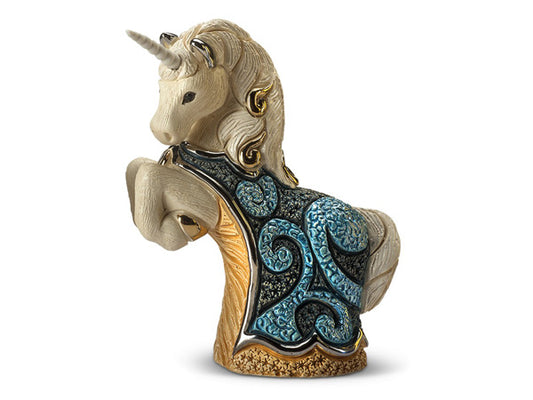 A porcelain figurine of a unicorn reared up on it's hind legs. The unicorn wears a cape of blue and grey with swirls and shows off a golden belly.  The piece is finished in a pearlescent enamel & silver and gold painted accents