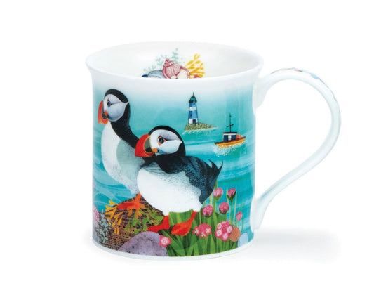 A fine bone china mug showcases a colourful illustration of various puffins perched or flying around their coastal habitat. The puffins display their classic black and white colourings with vivid orange beaks and feet as they rest upon a rocky clifftop. Surrounding their feet are richly coloured foliage, with shells peeking out from the cliff. In the background, a deep blue ocean stretches with small boats and a blue lighthouse visible in the distance. The clifftop foliage continues down the mug handle, wit