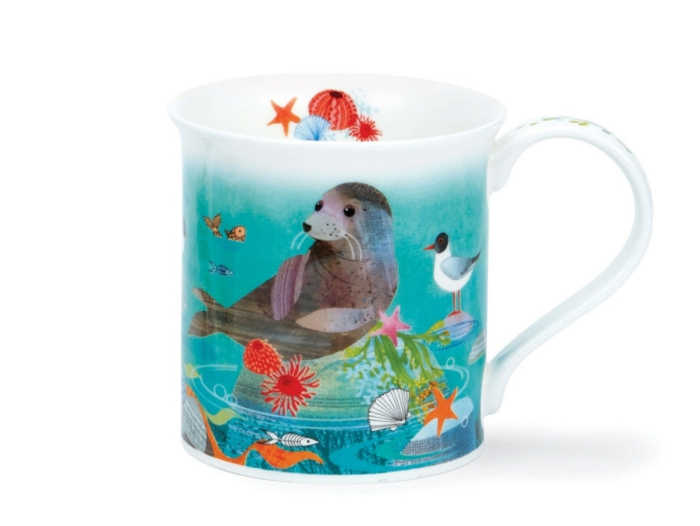 A fine bone china mug with straight sides and a subtly fluted top, featuring a delightful design of swimming seals in a vibrant turquoise ocean. Colourful shells, rocks, and seaweed dot the scene. A string of seaweed gracefully lines the handle, while the inner rim showcases a charming collection of seafloor flora on one side and an adorable seated seal on the other.