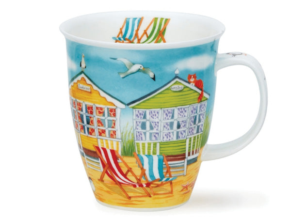 A fine bone china mug, with a wrap-around design featuring illustrations of a series of four beach huts in blue, red, yellow, and green set against a blue sky with seagulls overhead. The sandy beach is adorned with striped deck chairs, a basket of goodies, some shells, and two terns in the foreground showcasing a traditional British seaside.