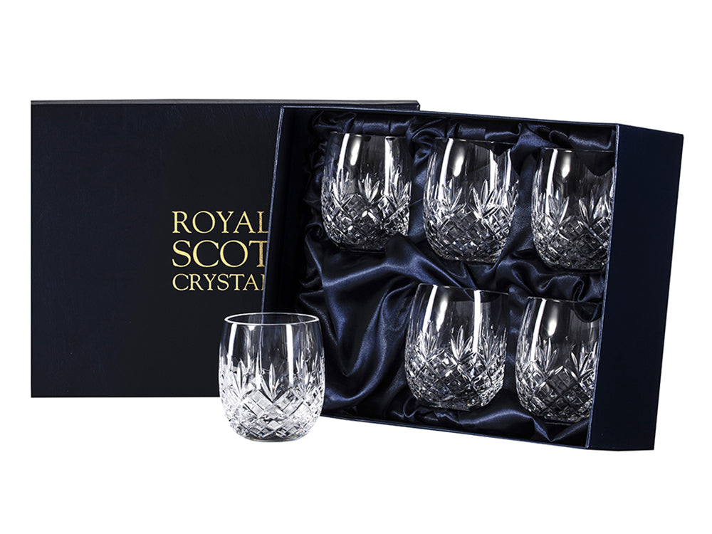 A set of six rounded gin and tonic tumblers with a cut design around the exterior, arriving in a navy-blue presentation box