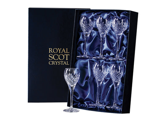 A set of six crystal port glasses with a cut pattern, featuring a bed of diamonds and three-pointed fan above it. They come in a navy-blue silk-lined presentation box with gold branding on the lid.